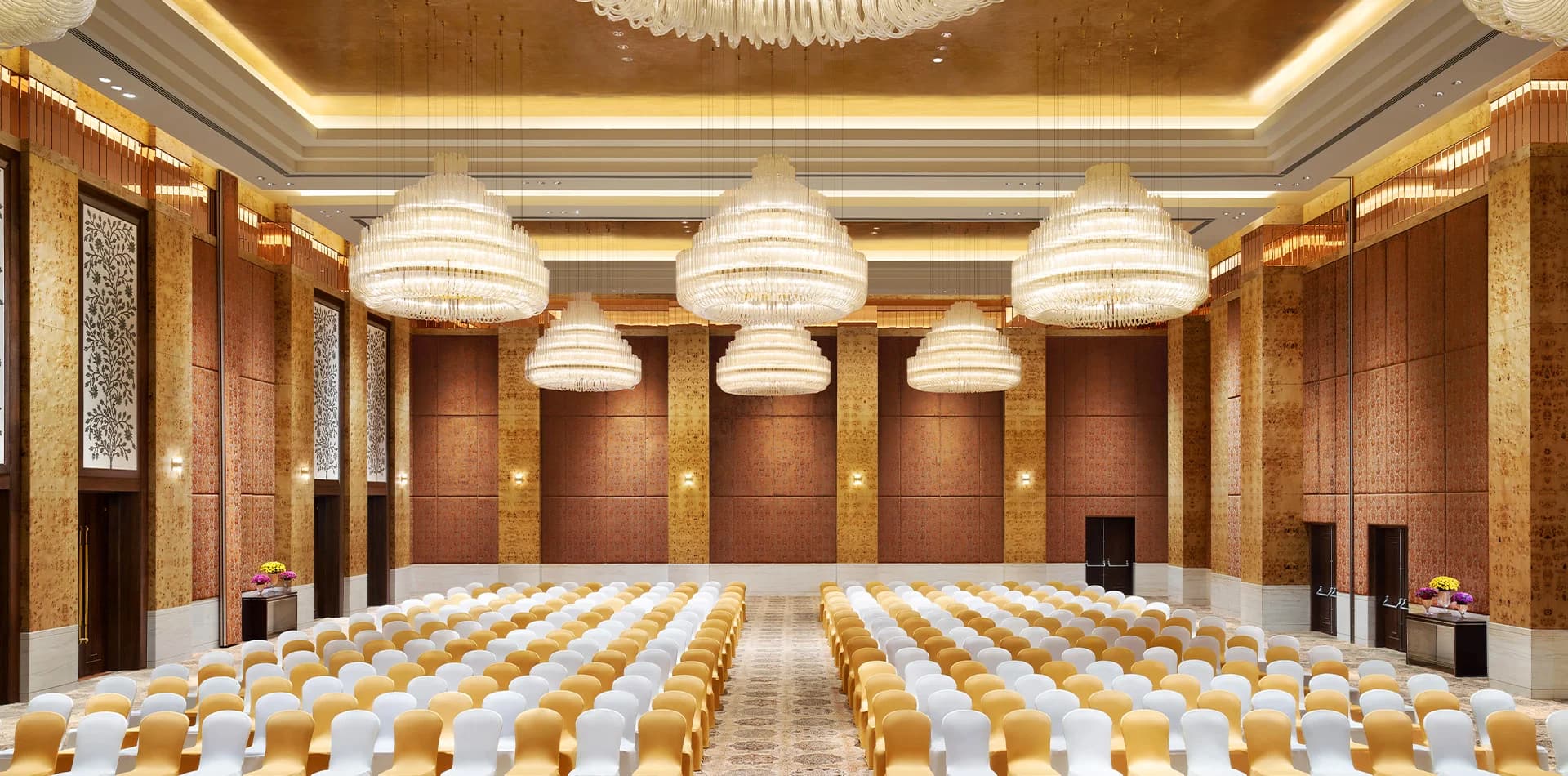 The Grand Ballroom at The Leela Gandhinagar with rows of tiered crystal chandeliers and gilded walls
